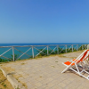Due sdraio arancioni rivolte verso il mare.