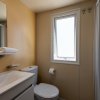 Bagno con finestra, lavabo e doccia discreta.