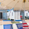 Bungalow su una spiaggia con lettini e ombrelloni.