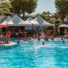 Piscina con bagnanti e ombrelloni.