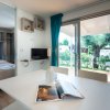 Tavolo bianco, rivista, TV e porta-finestra su veranda.