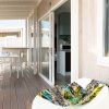 Terrazza con tavolino e sedie, aperta sull'interno.