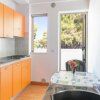 Cucina con mobili arancioni e tavolo apparecchiato.