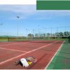 Campo da tennis vuoto con racchette e palline.