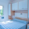 Camera da letto luminosa con letto matrimoniale e parete attrezzata.