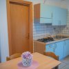 Cucina con mobili azzurri e tavolo in legno.