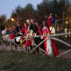 Gruppo di persone con cappelli in posa dietro una staccionata di legno.