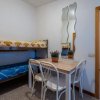 Letto a castello, tavolo con sedie e specchiere ondulate.