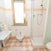 Bagno con cabina doccia, lavandino, bidet e finestra.