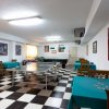 Sala giochi con tavoli e tavolo da ping pong.
