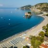 Spiaggia con ombrelloni e mare calmo.