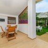 Veranda con tavolo, sedie e vista sul giardino.