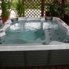 Spa con acqua sotto una copertura in legno e piante.