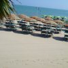 Spiaggia con ombrelloni e lettini sulla sabbia.