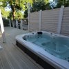 Vasca idromassaggio su terrazza con pavimento in legno.