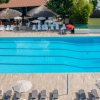 Piscina con sedie a sdraio e ombrelloni.