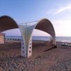 Una struttura con tetto a cupola sulla spiaggia al tramonto.