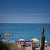 Una spiaggia con ombrelloni colorati e persone in acqua.