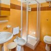 Bagno con piastrelle arancioni, doccia, lavabo, bidet e WC.