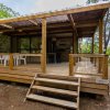 Bungalow in legno con ampia veranda immerso nel verde.