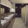 Bagno pubblico con lavandini moderni e cabine chiuse.