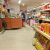 Corsia di un negozio con scaffali di snack e bottiglie di vino.