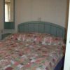 Letto matrimoniale con copriletto decorato a motivi floreali.